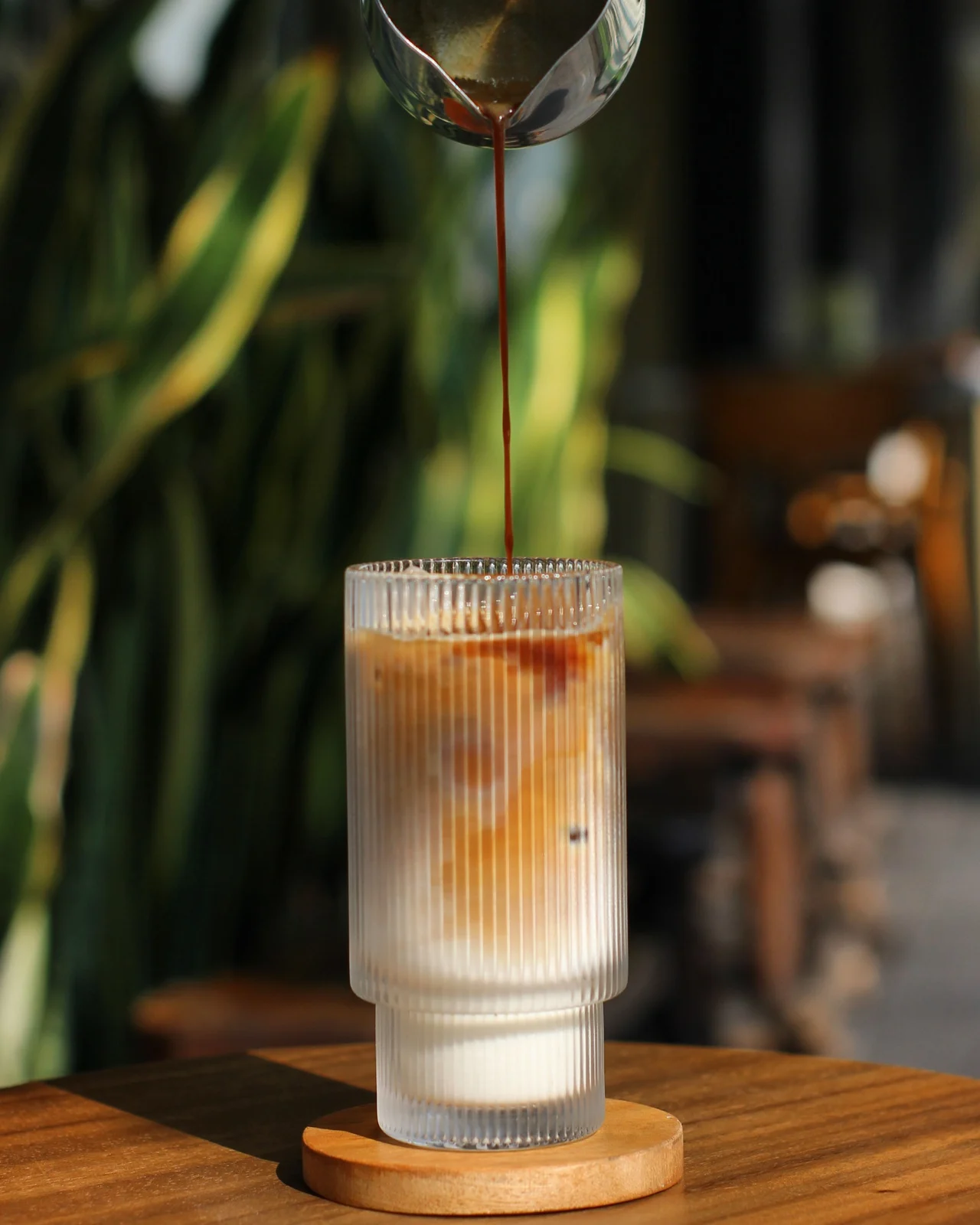 Espresso dituang ke dalam susu di Kana Cafe